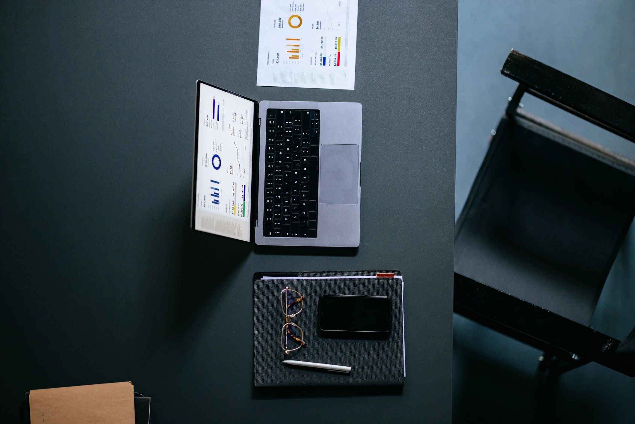 Overhead view of desk with laptop and notebook