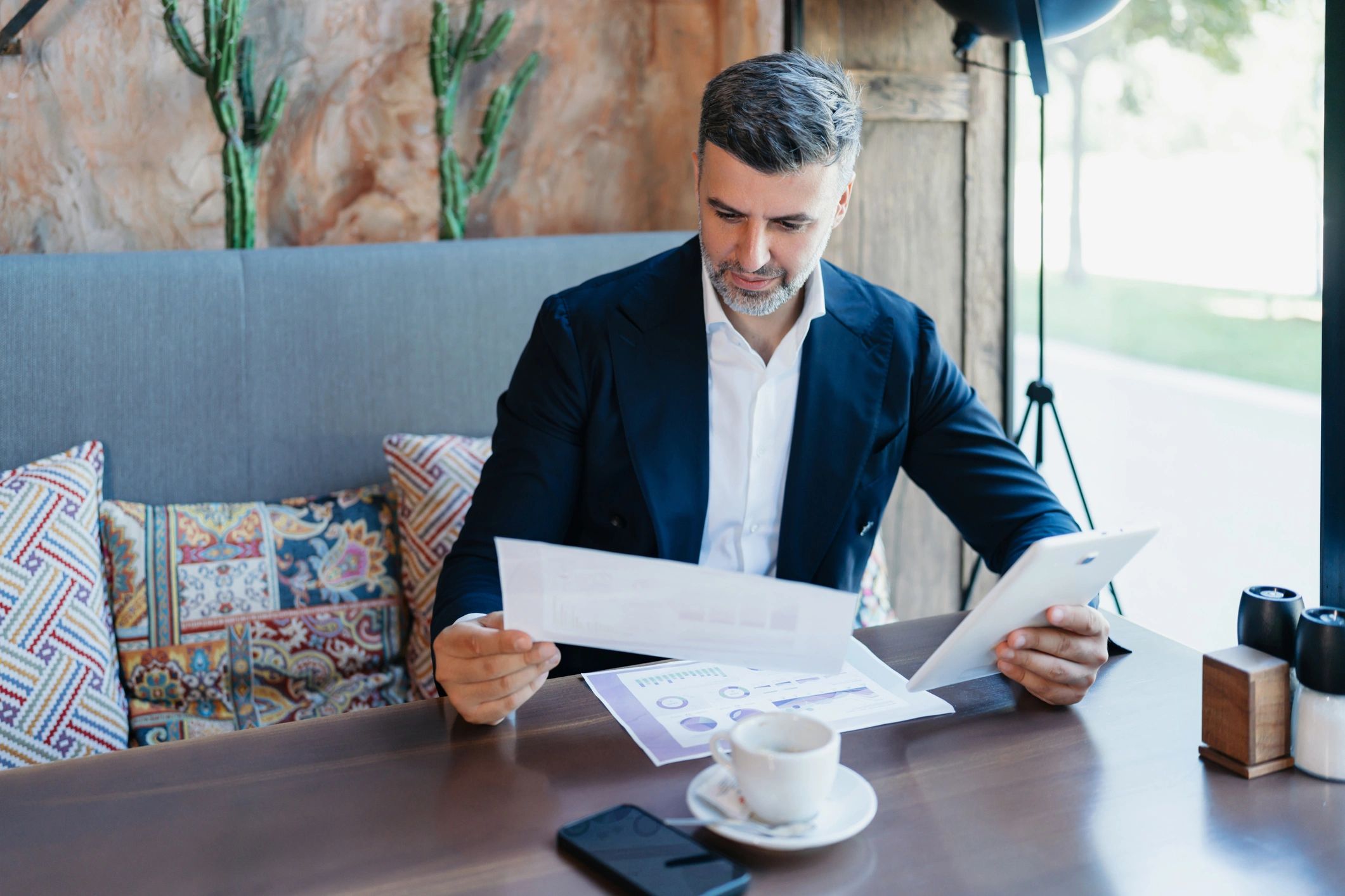 Professional analyzing performance documents with a tablet